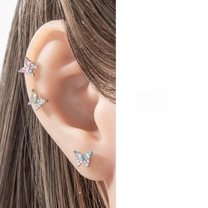 Macro shot of three colors of butterfly cartilage earrings with zircon butterfly set
