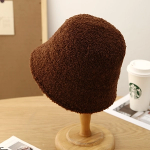 Detailed close-up of dark brown plush teddy fleece fabric on a warm winter bucket hat