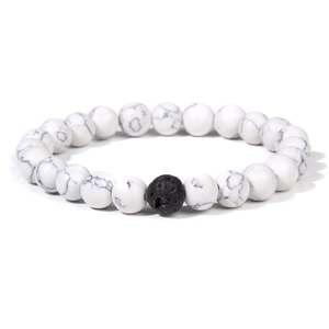 Detail of white turquoise marble beads with a single black lava rock bead on elastic cord
