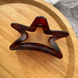 Detail view of the durable dark brown amber star hair claw clip and metal spring