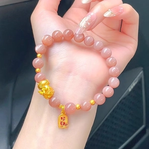 Detailed view of sunstone beaded bracelet featuring a gold Pixiu and lucky charm pendant