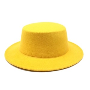 Detailed texture of a bright yellow wool felt flat top boater hat on white background