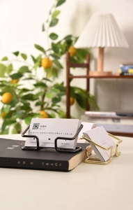 Detail of minimalist gold and black metal business card holders on a desk setup