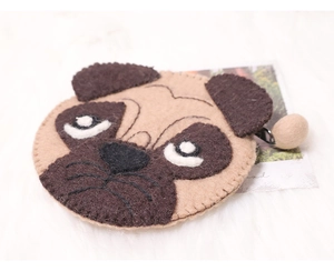 Close-up of beige felt pug dog coin purse with a round metal zipper pull on white fur