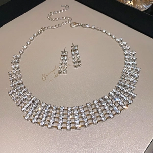 Detailed view of silver rhinestone jewelry set with rectangular necklace and drop earrings