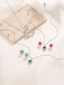 Detailed view of jewelry sets featuring emerald-cut gemstones and diamond halos on stone base