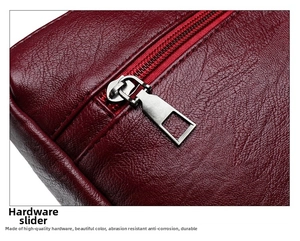 Close-up of durable silver metal zipper on burgundy pebble leather shoulder bag