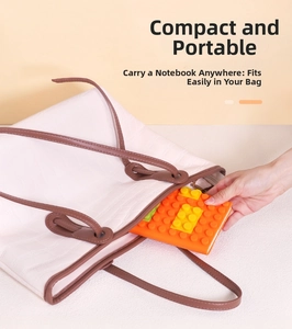 Detail showing the portable orange silicone notebook being placed into a tote bag