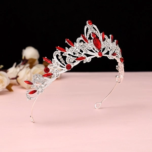 Detailed view of silver alloy bridal crown with luxury red crystals and filigree patterns