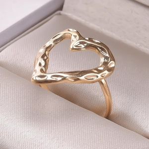 Detail of gold heart ring with hammered texture in beige silk jewelry display box