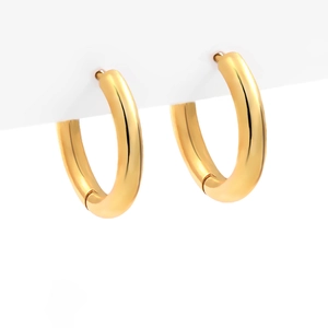 Detailed view of polished gold hoop earrings hanging on a minimalist display stand