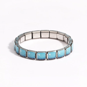 Detail of Italian modular charm bracelet in stainless steel with blue enamel star and moon