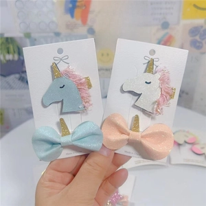 Close-up of pink and blue unicorn hair clips with glitter bows on display cards