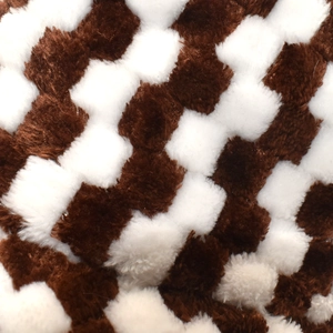 Macro shot of faux rabbit fur bucket hat showing brown and white checkerboard plush texture