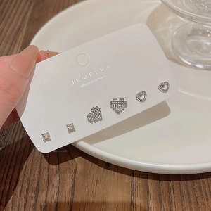 Primer plano del set de pendientes de plata S925 con corazones de circón y perlas redondas