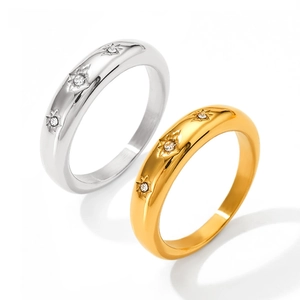 Detail view showing gold and silver rings with star engraving and sparkling diamond inlay