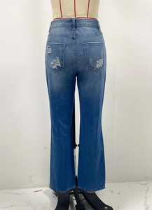 Dettaglio del design strappato e lavaggio sfumato sulle tasche posteriori dei jeans