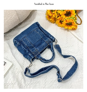 Close-up of blue denim tote bag with adjustable strap, textures, and sunflower decor