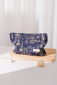 Detailed embroidery of yellow and white flowers on a dark blue cotton cosmetic bag