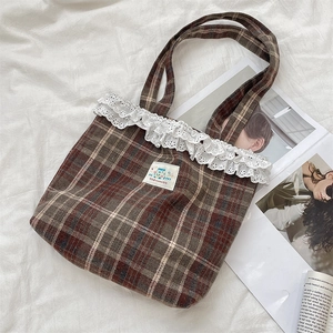Detail of vintage plaid tweed tote bag featuring delicate white lace trim and embroidery