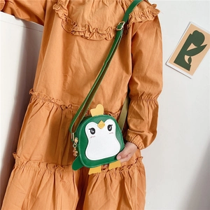 Close-up of cute green penguin kids bag with embroidery and flower metal zipper