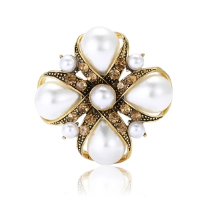 Vintage gold-tone baroque brooch with white teardrop pearls and brown crystals on white