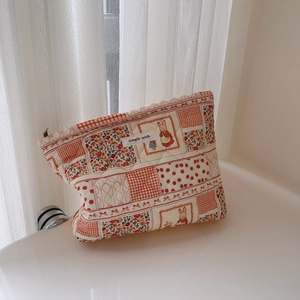 Close-up of quilted cotton makeup bag with floral patterns and a rabbit design
