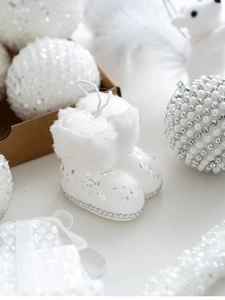 Close-up of white plush Christmas boots ornaments with sequins and festive glitter balls