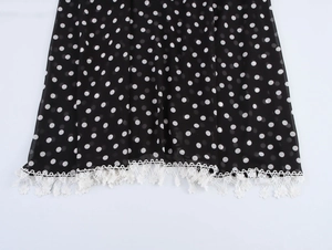 Détail de l'ourlet de robe en mousseline à pois avec dentelle blanche et bordures frangées