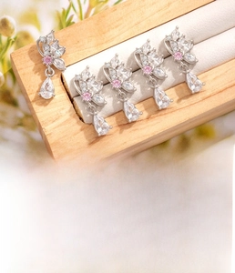 Detailed view of silver butterfly cartilage studs with zircon drops and steel screw backs