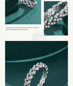 Macro detail of leaf-shaped silver ring with micro-paved zircons on green velvet