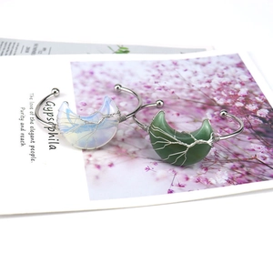 Detail of silver wire-wrapped moon bracelet featuring white opal and green agate stones