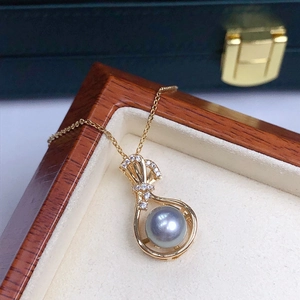 Detailed close-up of a lucky bag pearl necklace with gold finish and crystal accents