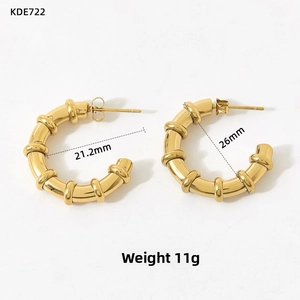Detail of 26mm gold-plated hoop earrings with bamboo texture and secure butterfly backs