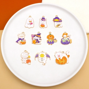 Set of 10 Halloween enamel charms featuring ghosts and pumpkins on a white plate