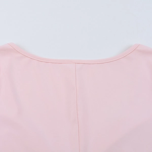 Détail de la robe rose montrant le décolleté en V profond et les coutures de qualité