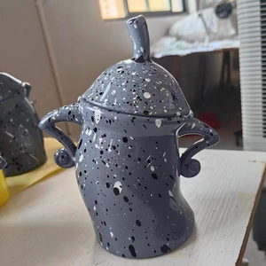 Gray speckled ceramic canister with attitude and matching lid in a unique cartoon style