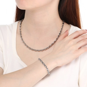 Polished stainless steel oval link chain necklace and bracelet set worn by a model