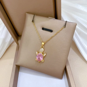 Macro shot of sea turtle pendant with pink zircon and white crystal pavé in a gift box