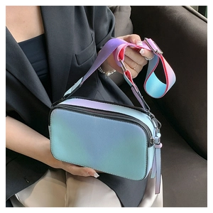Detail of gradient blue and purple camera bag with a wide strap on a female model