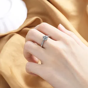 Close-up of sparkling heart zircon engagement ring on champagne silk background