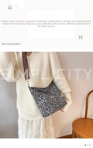 Detail of leopard print canvas bag with textured wide strap and gold metal hooks