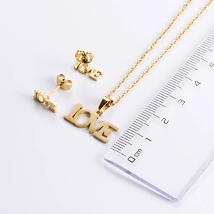 Comparaison de taille de l'ensemble collier et boucles d'oreilles LOVE avec une règle
