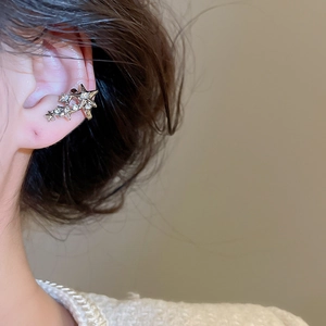 Détail du clip d'oreille en forme d'étoile avec strass étincelants sur l'oreille