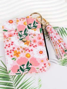 Floral print coin purse in pink with tassel pendant and snap closure on decorative background