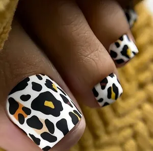 Gros plan de faux ongles de pieds mats avec motif léopard orange et noir élégant