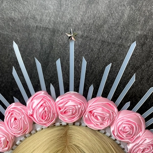 Detail of halo crown featuring pink satin roses, radial spikes, and a silver metal star