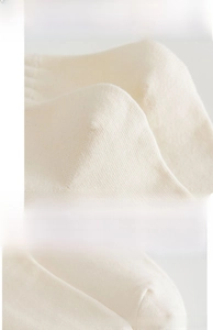 Détail de la chaussette en maille crème avec bord-côte élastique et talon renforcé durable