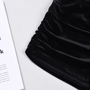 Close-up of black velvet shorts showing intricate pleated details and soft fabric texture