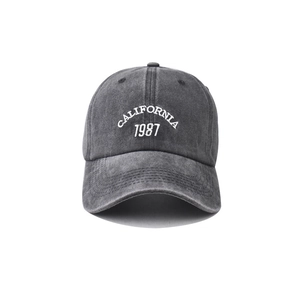 Close-up of white California 1987 embroidery on vintage washed dark grey baseball cap